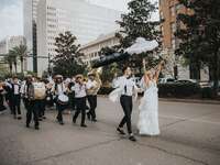 Bride and groom leading a New Orleans street band