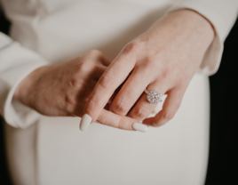 Woman's hands with cream wedding nail manicure and diamond ring