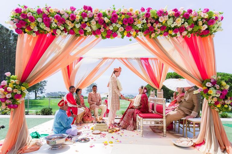 Bright pink mandap with draping and floral accents