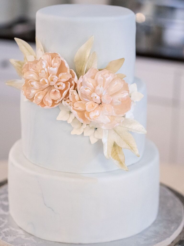 Three-tier spring floral wedding cake with pale flowers