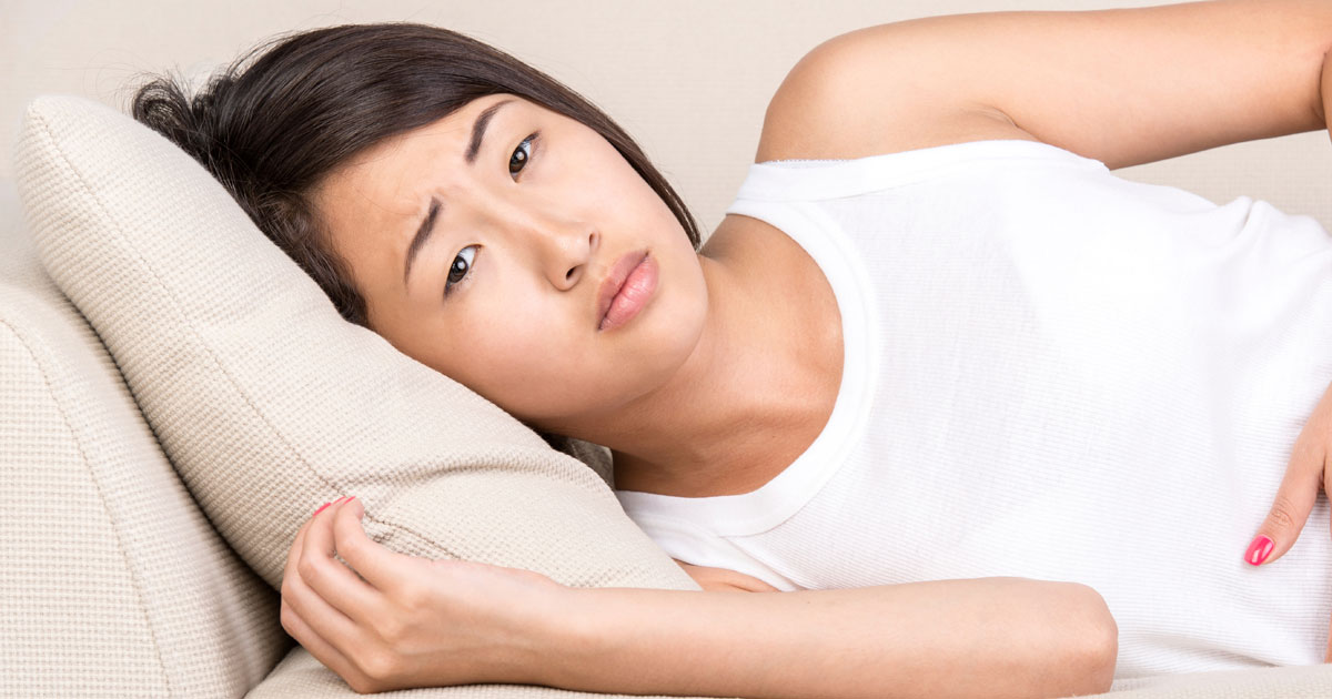 Woman lying on couch looking concerned