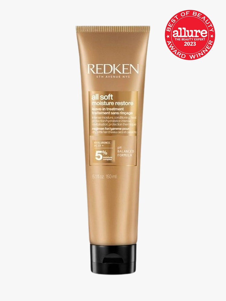 Redken All Soft Moisture Restore LeaveIn Treatment gold bottle with black cap on light grey background