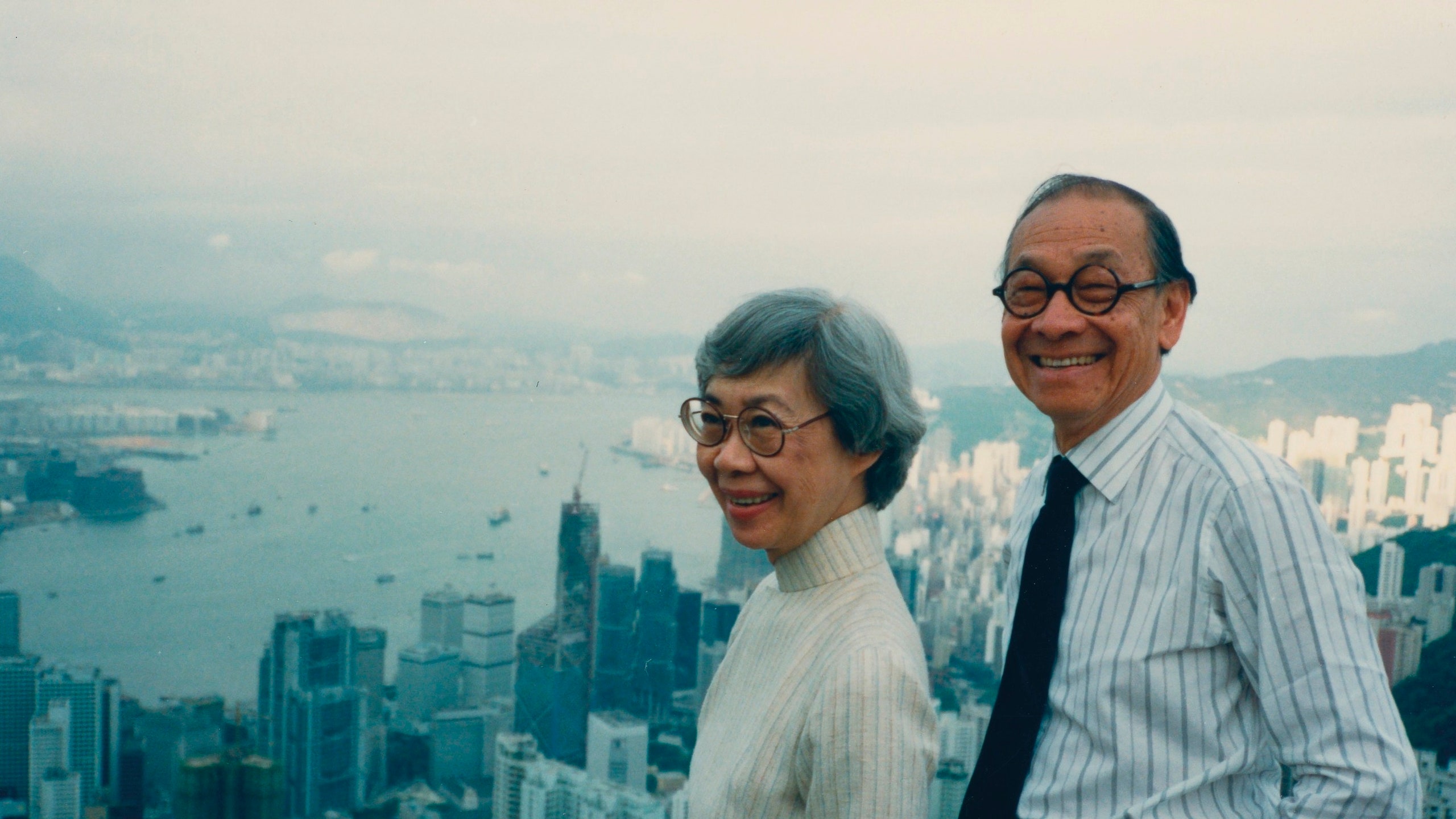 man and woman standing atop of city