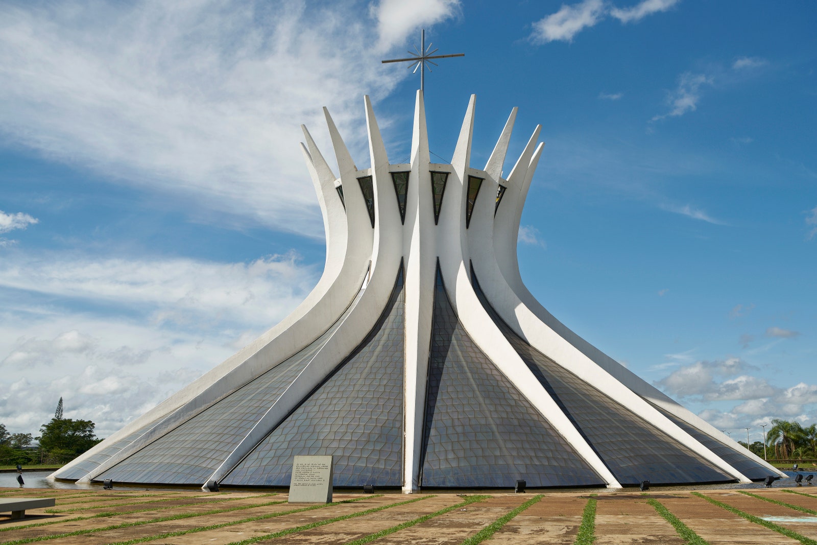 a circular building with white shards and a cross on the top