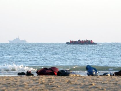 A group of people thought to be migrants, leave the beach in Gravelines, France, onboard a