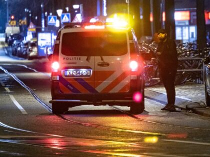 Police officers and vehicles deployed in Amsterdam to overview the curfew. Deserted street