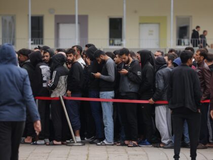 EISENHUETTENSTADT, GERMANY - OCTOBER 05: Men, most of them from Syria, queue for lunch at