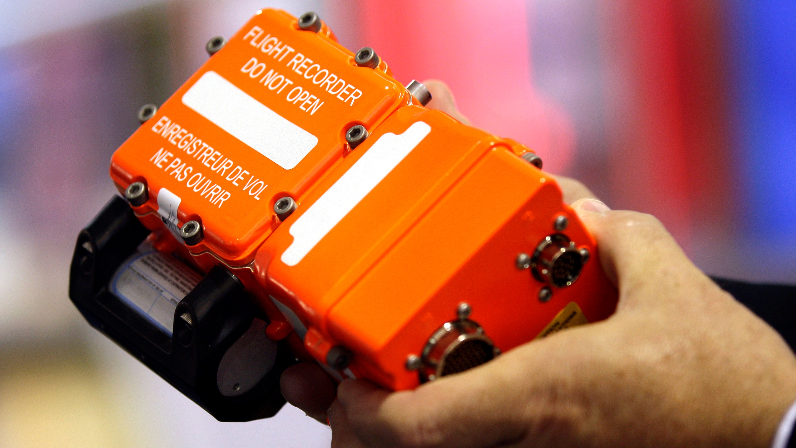 An employee holds an L3 Communications Corp. SRVIVR black box flight recorder on the third day of the Farnborough...