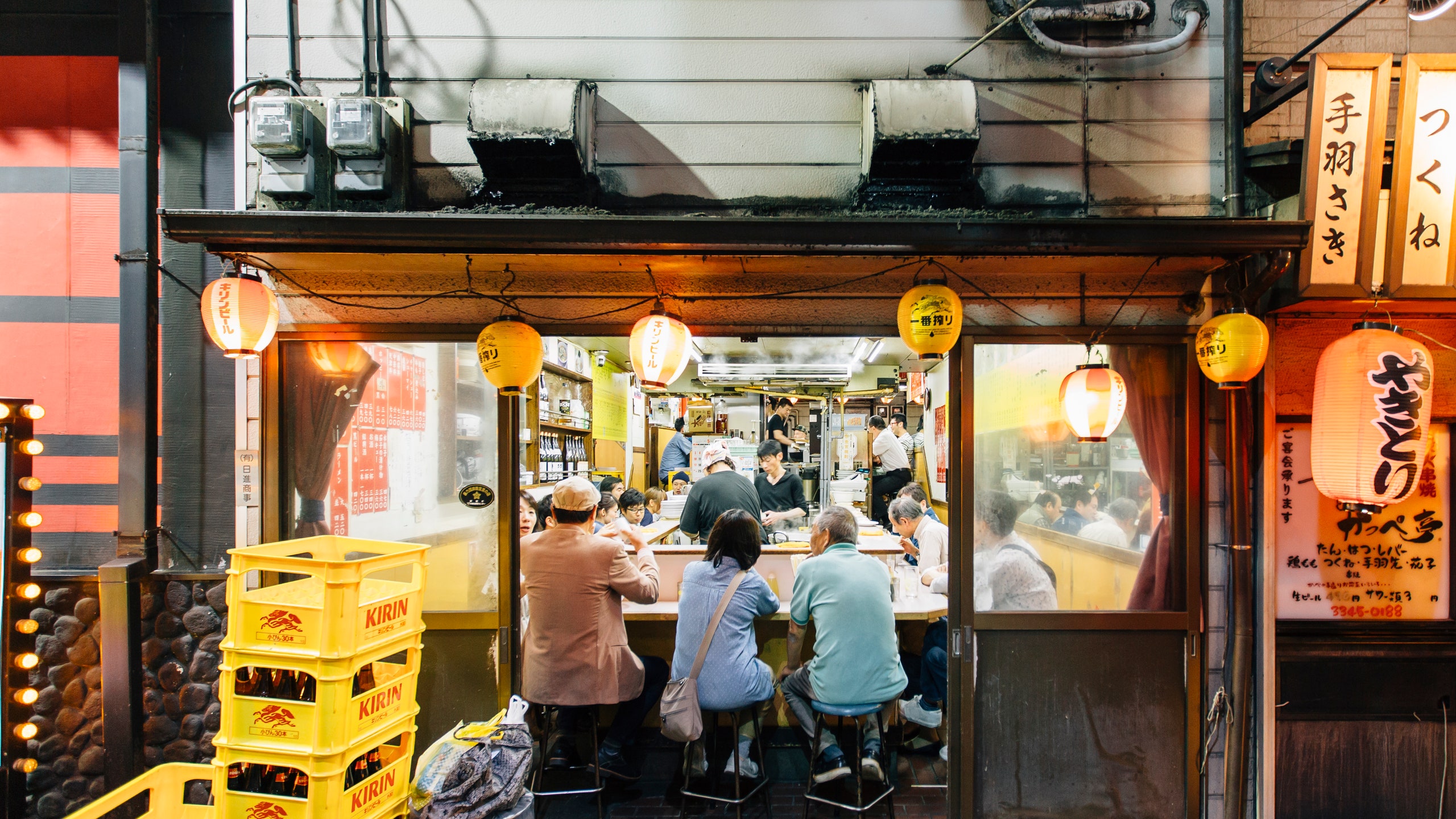 Locals eating out in a ramen restaurant at Yakitori alley Shinjuku Tokyo