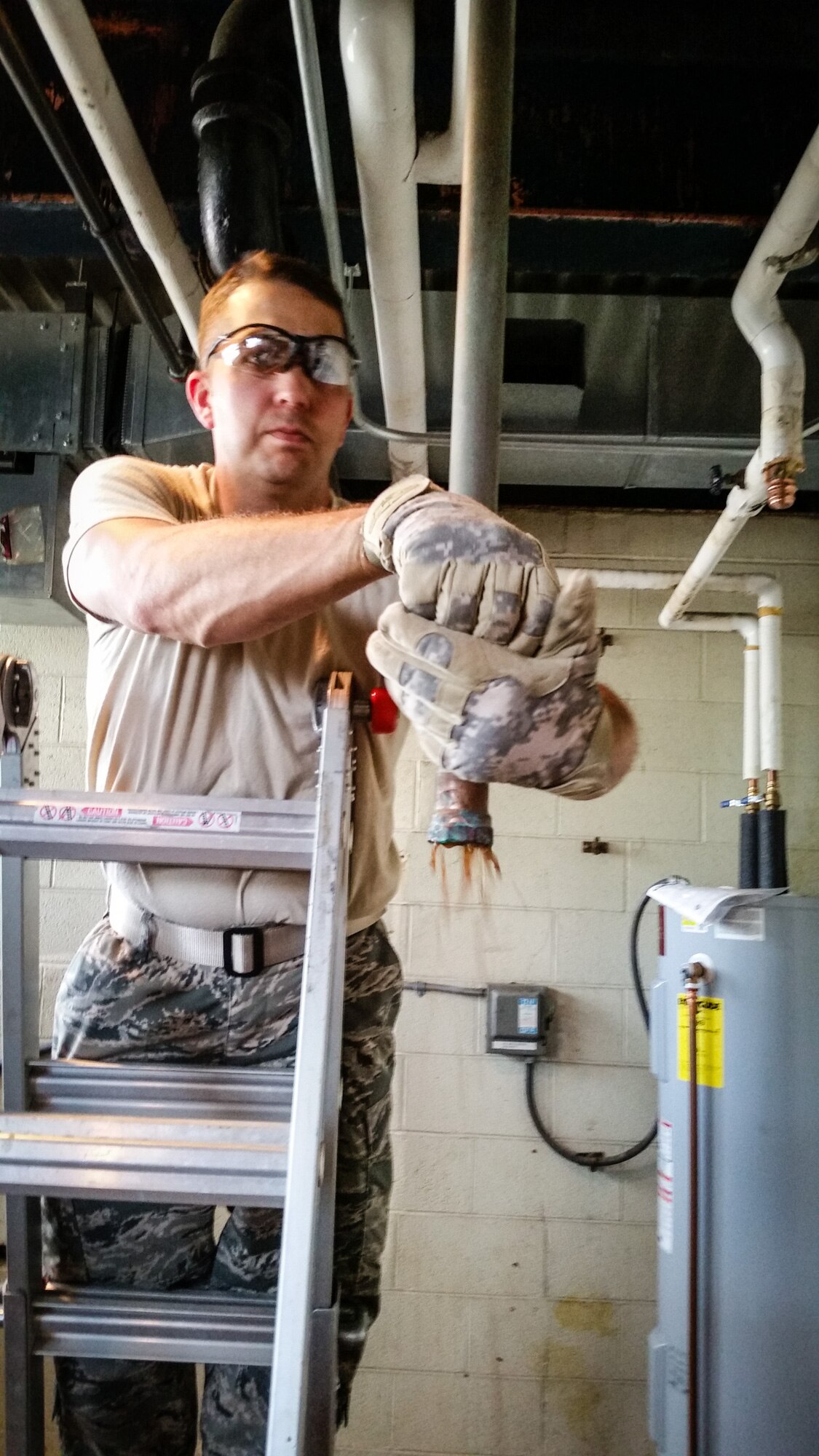 113th Civil Engineer Squadron Water and Fuel Systems Maintainer Staff Sgt. Michael Kammerer drains a section of pipe before removing it during his deployment for training to the U.S. Coast Guard Academy.  ((U.S. Air National Guard photo by Chief Master Sgt. Andrew Baker)