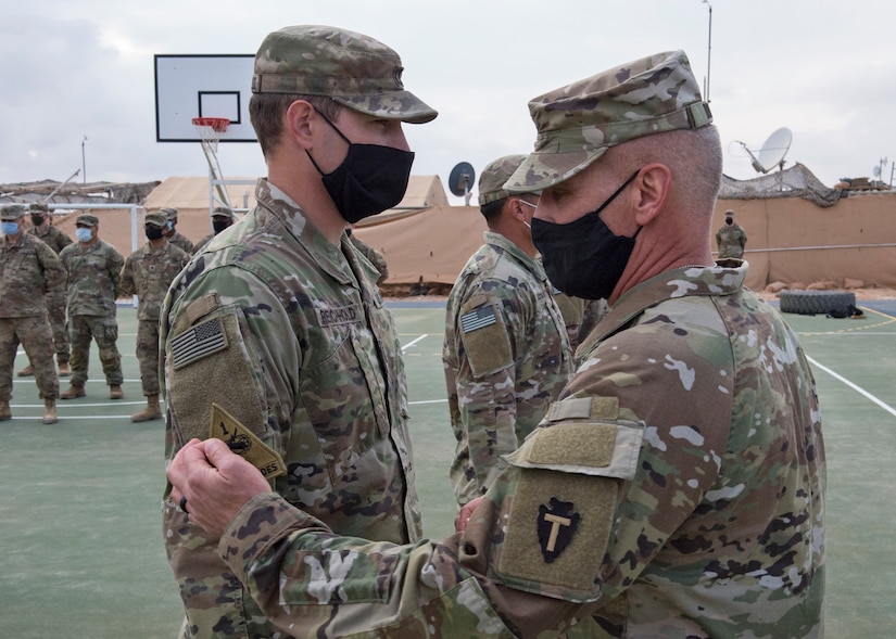 U.S. Soldiers of Alpha Company, 1st Battalion, 35th Armored Regiment, 2nd Heavy Brigade Combat Team, stand at attention to receive their shoulder sleeve insignia for former wartime service, commonly referred to as a combat patch, in a ceremony in Southwest Asia, Nov. 26, 2020.