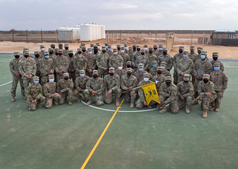 U.S. Soldiers of Alpha Company, 1st Battalion, 35th Armored Regiment, 2nd Heavy Brigade Combat Team, stand at attention to receive their shoulder sleeve insignia for former wartime service, commonly referred to as a combat patch, in a ceremony in Southwest Asia, Nov. 26, 2020.