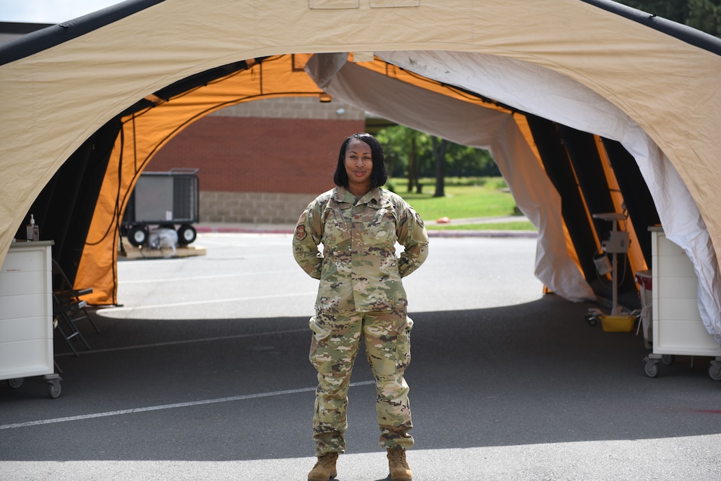 A woman stands in uniform.