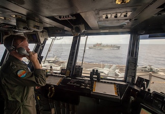 Lt. Clint Vance observes from primary flight control as USS Carl Vinson (CVN 70) conducts a vertical replenishment with USNS Richard E. Byrd (T-AKE 4) in the Philippine Sea.