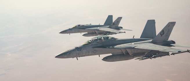 Two U.S. Navy F/A-18E Hornets fly alongside a U.S. Air Force KC-135 Stratotanker over the U.S. Central Command area of responsibility, Oct. 15, 2024. The F/A-18E is deployed to the U.S. 5th Fleet area of operations to help ensure maritime security and stability In the Middle East region. (U.S. Air Force photo) (This photo has been altered for security purposes by blurring out names on aircraft)