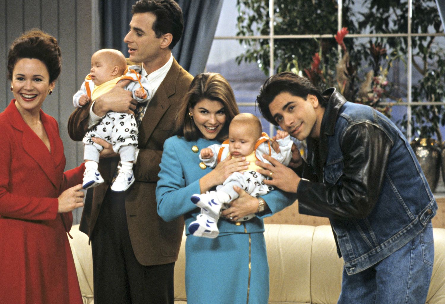 Image may contain John Stamos Human Person Lori Loughlin People Gail Edwards Clothing Apparel Family Baby and Coat