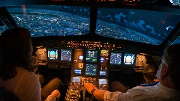 Pilot und Co-Pilot steuern ein Flugzeug im Cockpit.