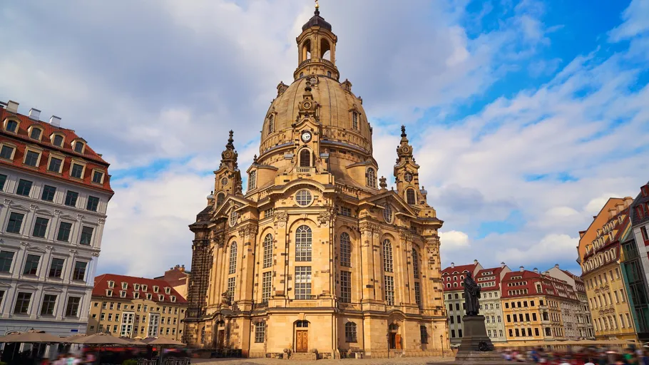 Barocke Kirche steht majestätisch unter bewölktem Himmel.