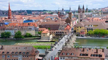 Stadtansicht mit historischen Gebäuden und einem Fluss.