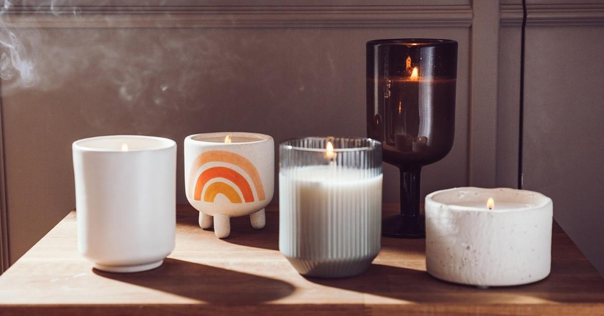 Photo of five different lit candles on a wooden table