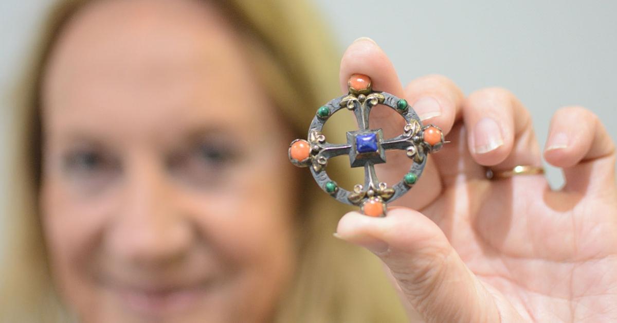 Flora Steel holds up the $25 antique brooch she bought. 