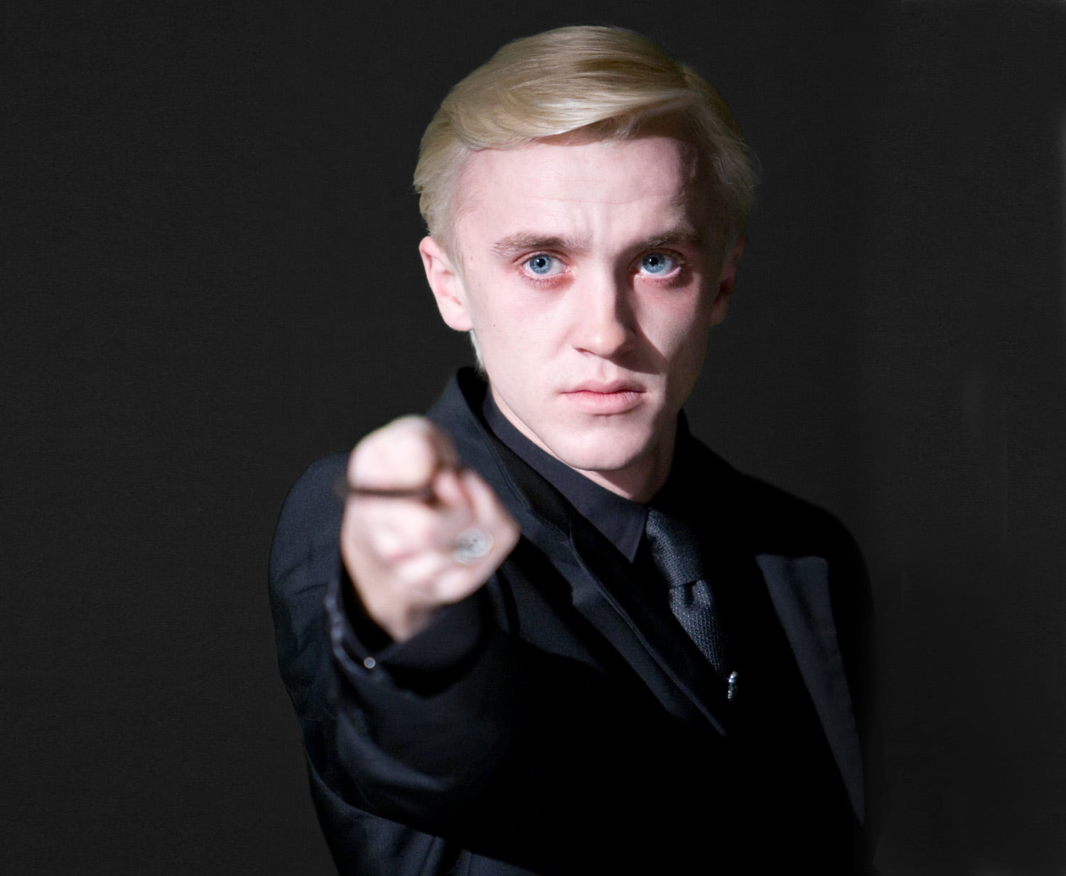 Draco Malfoy holds up his wand