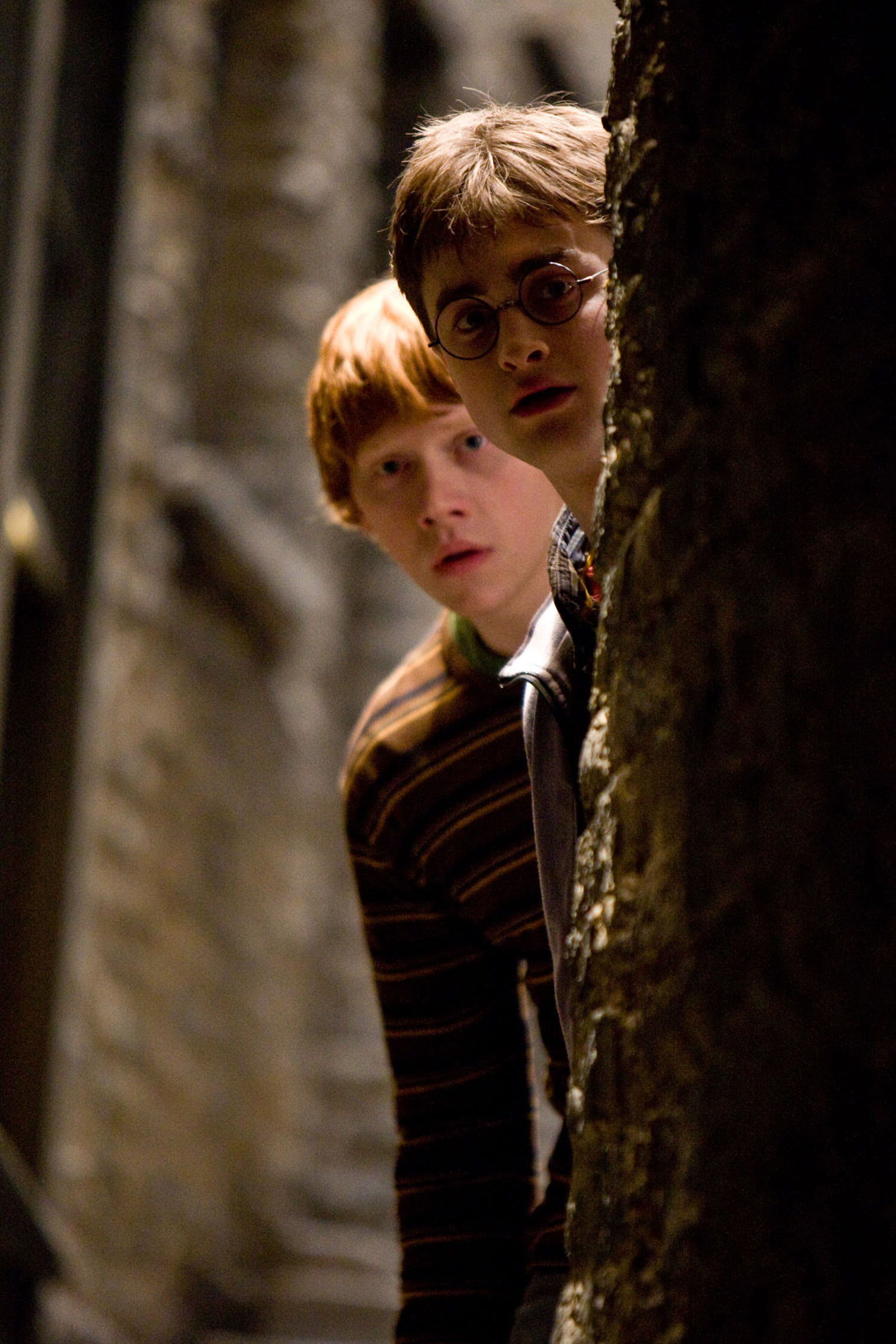 Harry and Ron look out from behind a wall