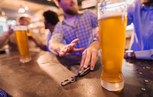 Limited - Man reaching for glass of beer and friend stopping him