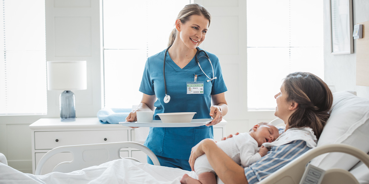 A mother and her new baby talking to a nurse in a private hospital room.