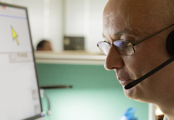 Man looking at screen wearing headset