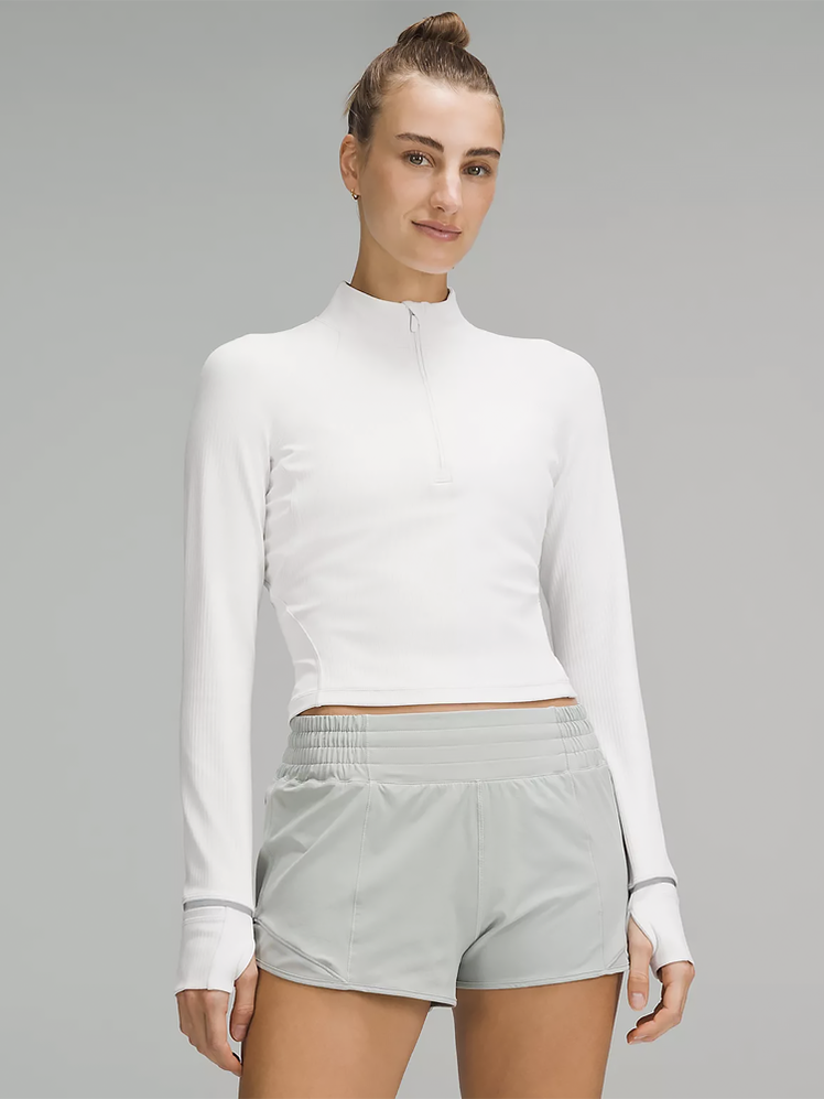 It's Rulu Ribbed Cropped Half Zip in white color way on model on dark gray background