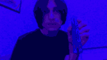 a man is holding a blue object in front of a purple wall .