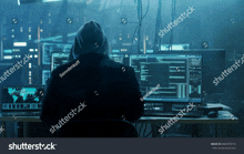 a man in a hoodie is sitting in front of a computer