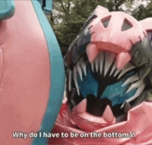 a pink and blue monster is standing next to another monster and says `` why do i have to be on the bottom ? ''