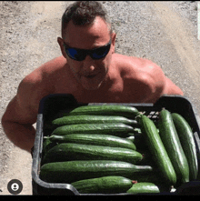 a shirtless man holds a crate of cucumbers with the number 9 in the corner