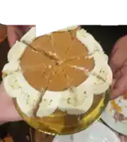 a person holding a cake that has been cut into slices