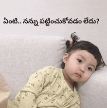 a baby is laying on a couch with a caption in a language other than english