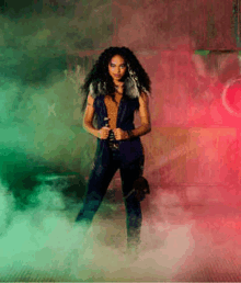 a woman with long curly hair is standing in a room with smoke coming out of the walls .