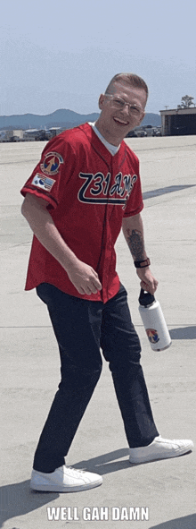 a man wearing a red baseball jersey with the number 73 on it