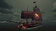 a pirate ship is floating on top of a body of water in the dark .