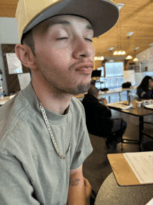 a man wearing a hat and a necklace that says california