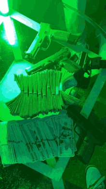 a stack of 100 dollar bills sits on a table with guns