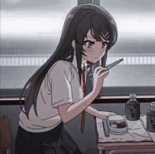 a girl is sitting at a desk with chopsticks and a bottle of tea