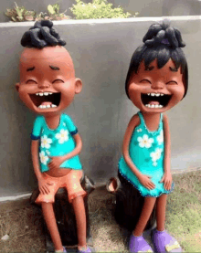 two statues of a boy and a girl are laughing together