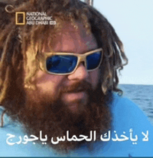 a man with dreadlocks and a beard is wearing sunglasses and a national geographic logo