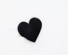 a black heart painted on a white wall .