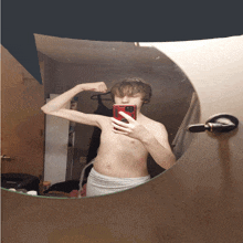 a young man taking a picture of himself in a bathroom mirror