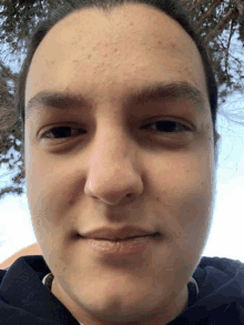 a close up of a young man 's face with a hoodie on .