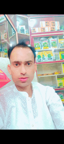 a man in a white shirt is taking a selfie in front of a display of seeds