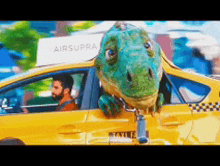 a dinosaur is sticking its head out of a yellow taxi cab